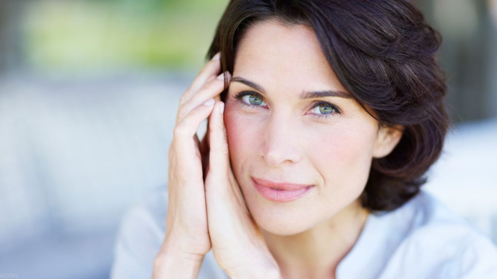 woman gently touching her face (model)