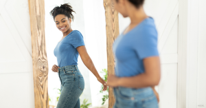 Woman in The Woodlands, TX admiring her tummy tuck results in the mirror
