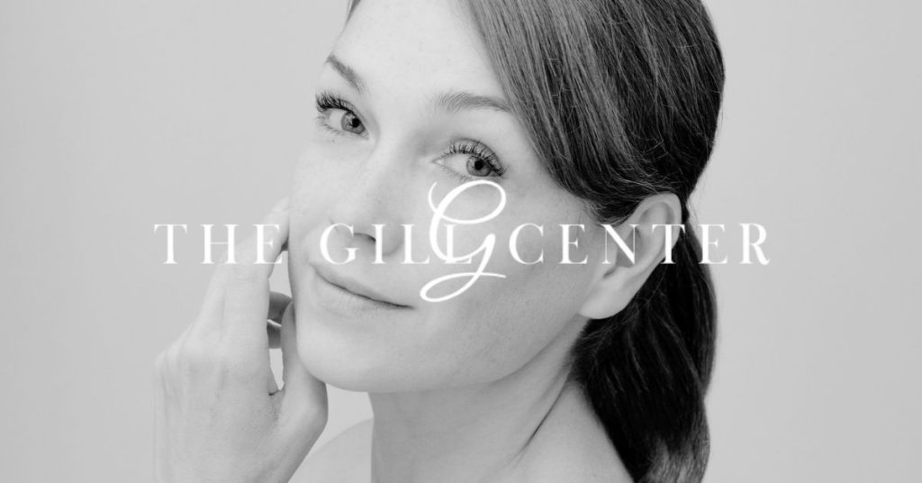 The Gill Center logo over a beautiful woman admiring her facelift results
